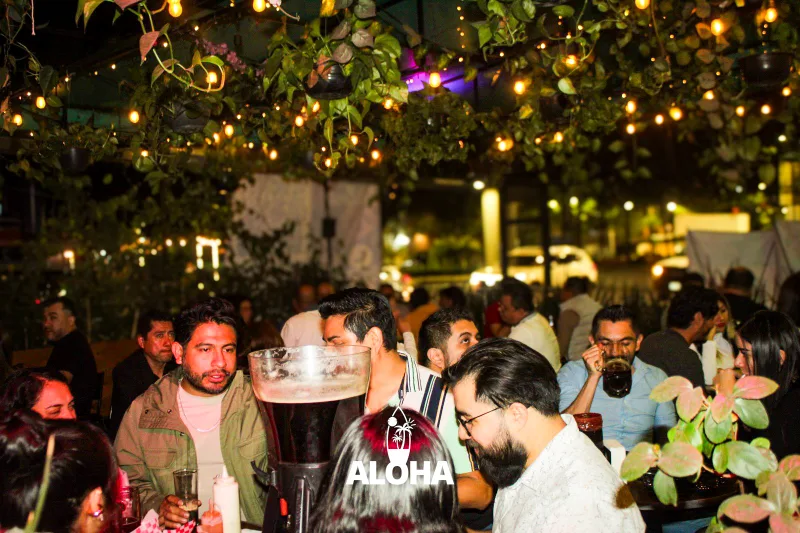 Terraza Aloha Coyoacán de noche con string lights y gente